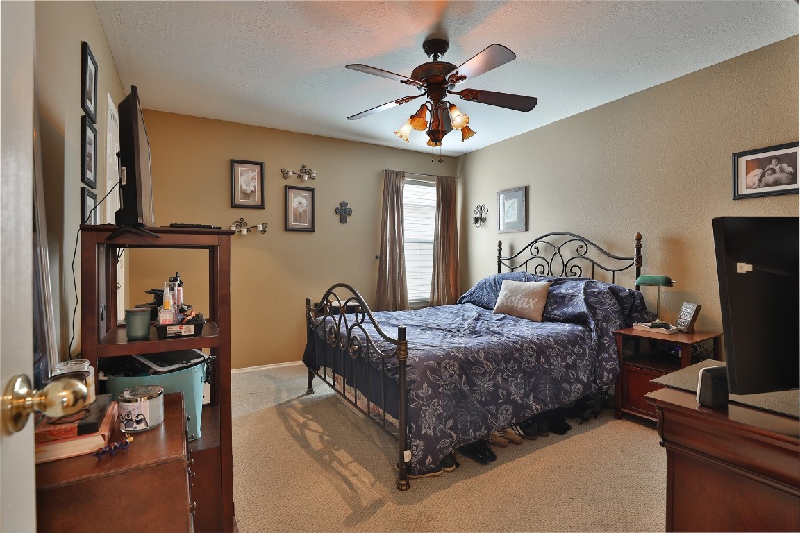 21711 Cascade Hollow Lane Spring, TX 77379 - Photo 12 of 24 a bedroom with a bed and a chandelier