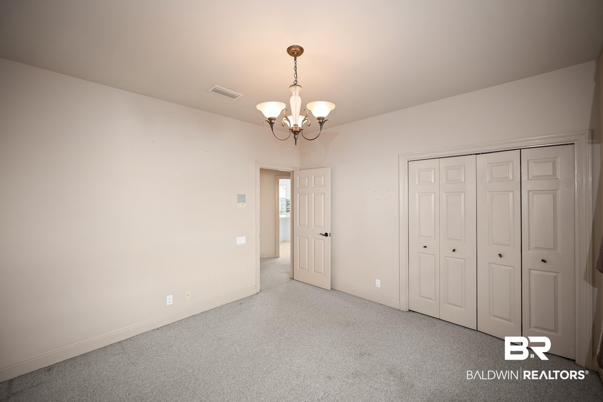8591 Bay Harbor Road Elberta, AL 36530 - Photo 36 of 56 Unfurnished bedroom featuring a chandelier and a closet