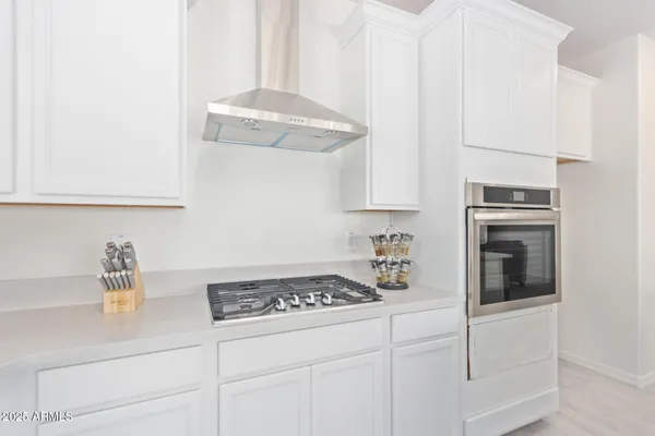 a kitchen with white cabinets and appliances