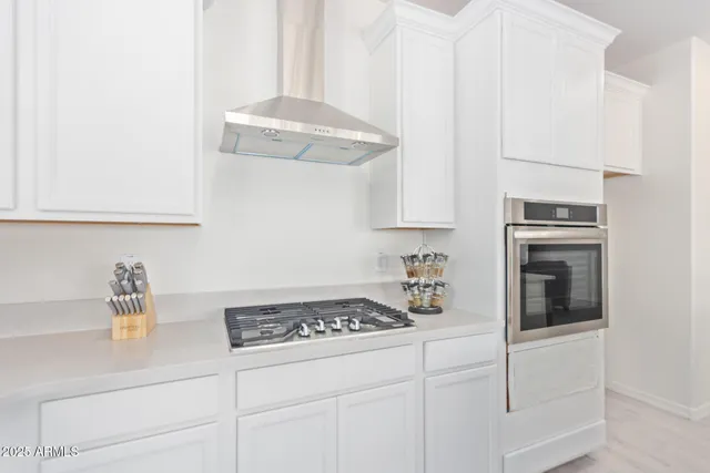 a kitchen with white cabinets and appliances