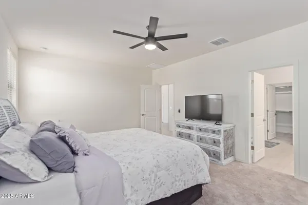 a bedroom with a bed window and a flat screen tv