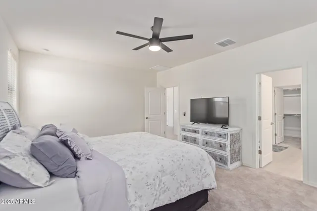 a bedroom with a bed window and a flat screen tv