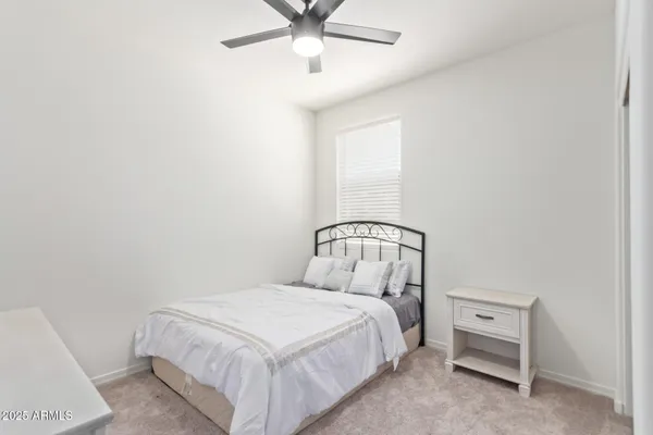 a bedroom with a bed and a ceiling fan