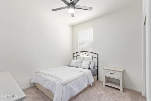 a bedroom with a bed and a ceiling fan