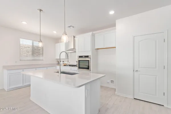 a kitchen with kitchen island a sink appliances and cabinets