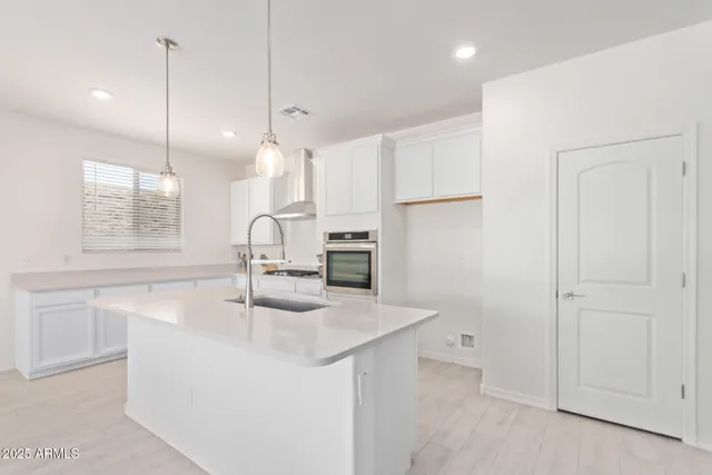 a kitchen with kitchen island a sink appliances and cabinets