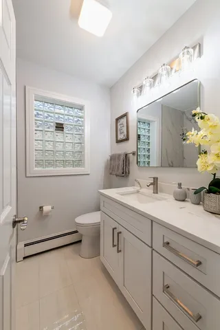 a spacious bathroom with a granite countertop sink a toilet and a mirror
