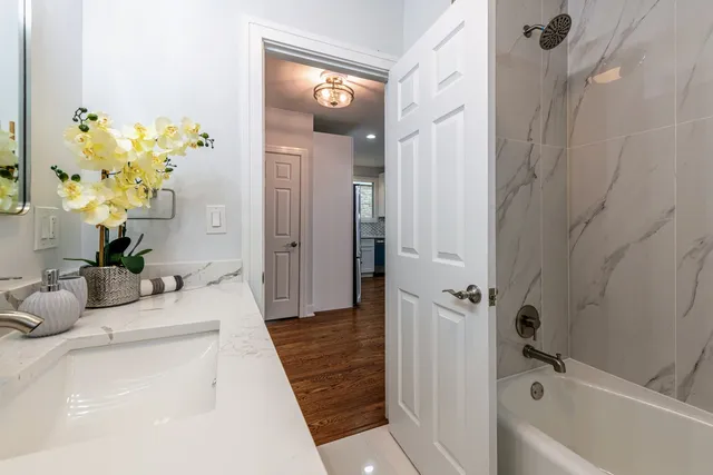 a bathroom with a granite countertop sink a toilet and shower