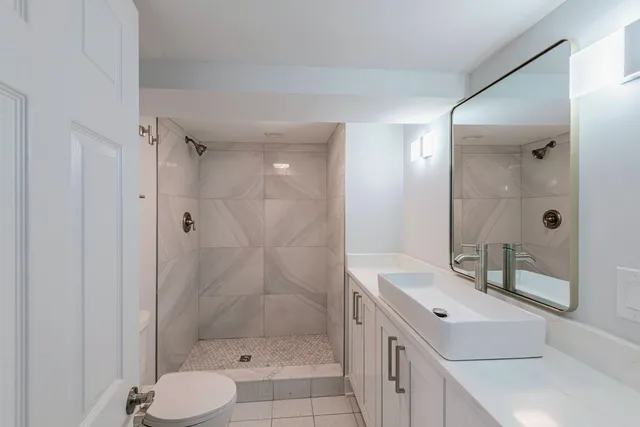 a bathroom with a shower sink and mirror