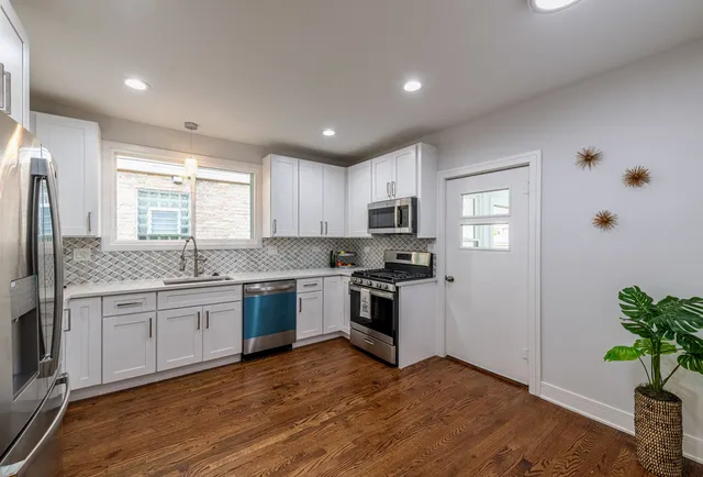 a kitchen with granite countertop a stove a sink and a refrigerator