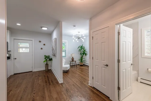 a view of a hallway with wooden floor and closet