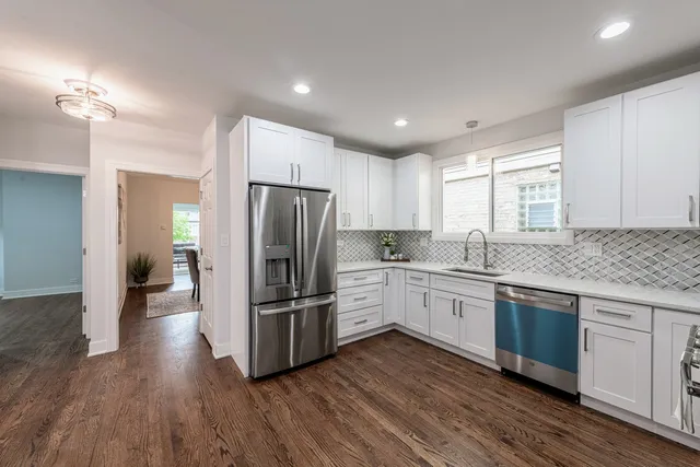 a kitchen with wooden floors and stainless steel appliances