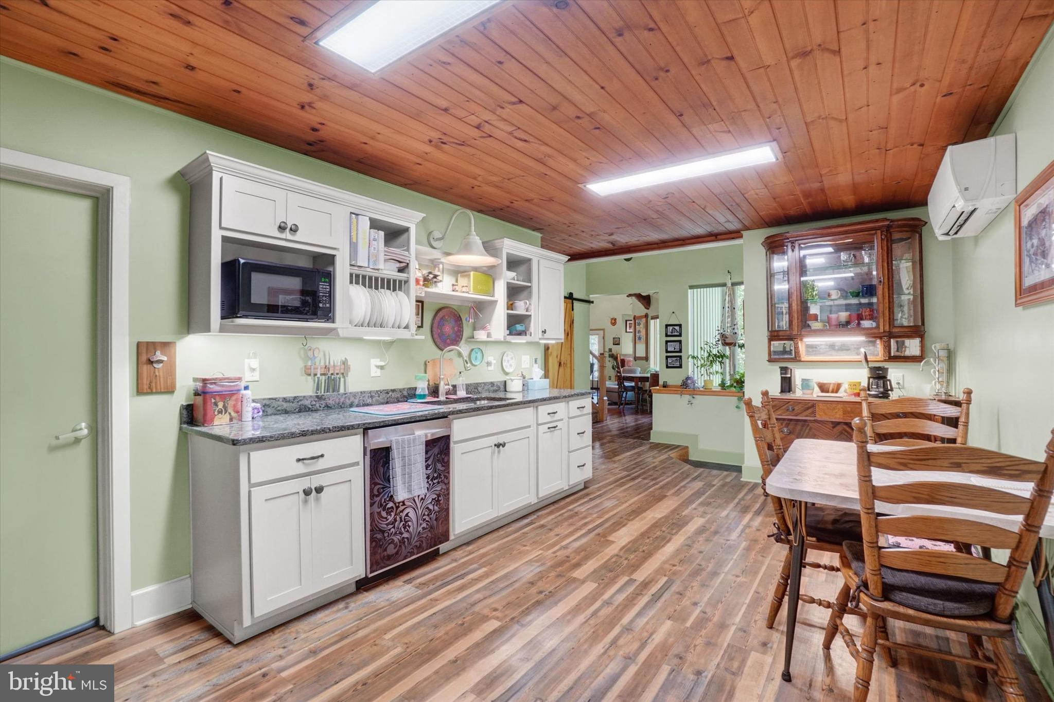 127 Halls Road Red Lion, PA 17356 - Photo 16 of 133 a large kitchen with kitchen island granite countertop lots of wooden cabinets a sink dishwasher a dining table and chairs with wooden floor