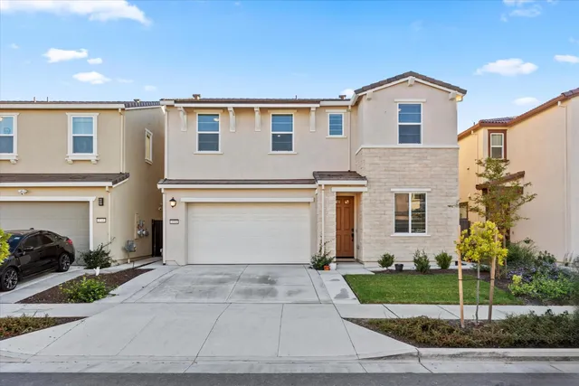 a front view of a house with a yard and garage