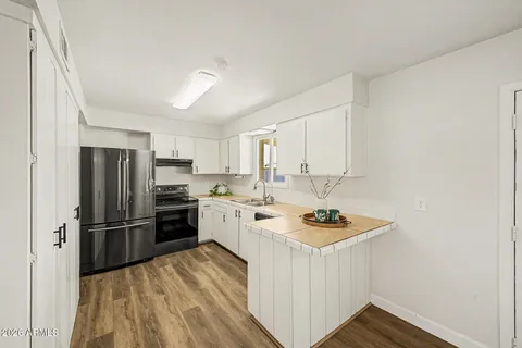 a kitchen with stainless steel appliances granite countertop a refrigerator stove sink and cabinets