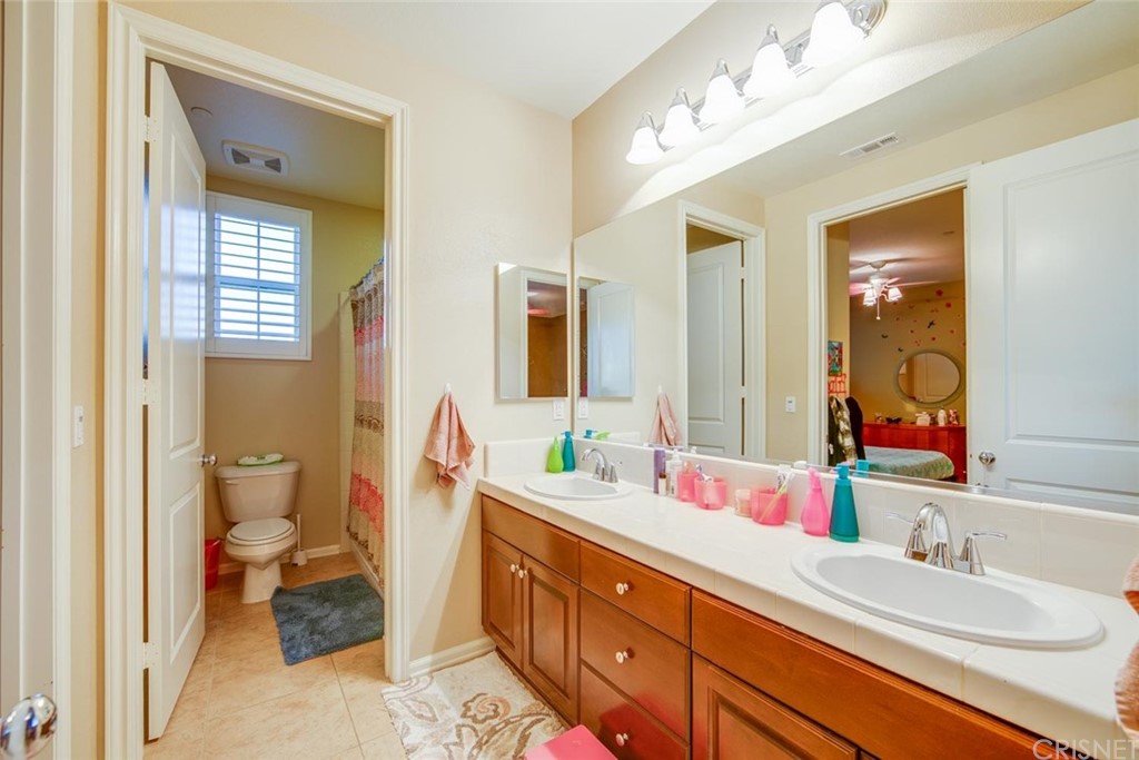 20855 Piazza Way Porter Ranch, CA 91326 - Photo 12 of 38 a bathroom with a double vanity sink mirror and toilet