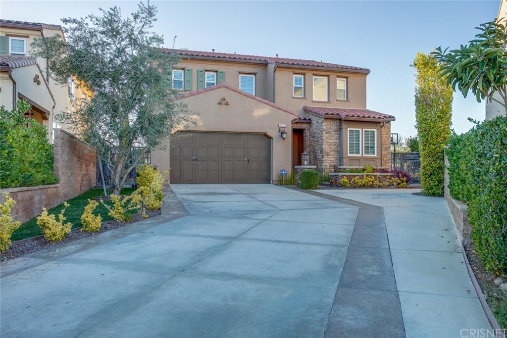 20855 Piazza Way Porter Ranch, CA 91326 - Photo 2 of 38 a front view of a house with a yard and garden