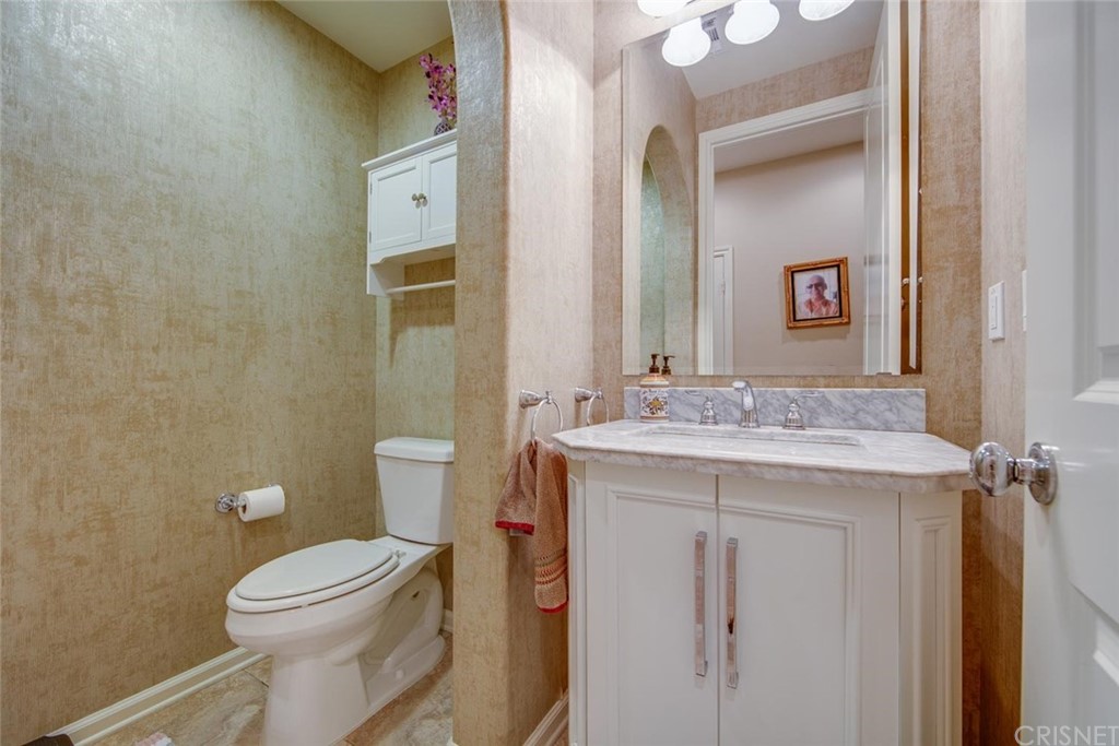 20855 Piazza Way Porter Ranch, CA 91326 - Photo 5 of 38 a bathroom with a granite countertop sink a toilet and a mirror
