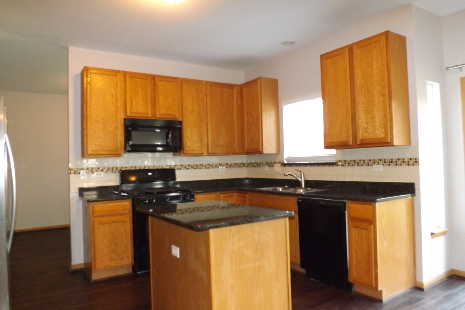 1865 Cattail Circle Aurora, IL 60504 - Photo 4 of 14 a kitchen with stainless steel appliances granite countertop a stove a sink and a microwave