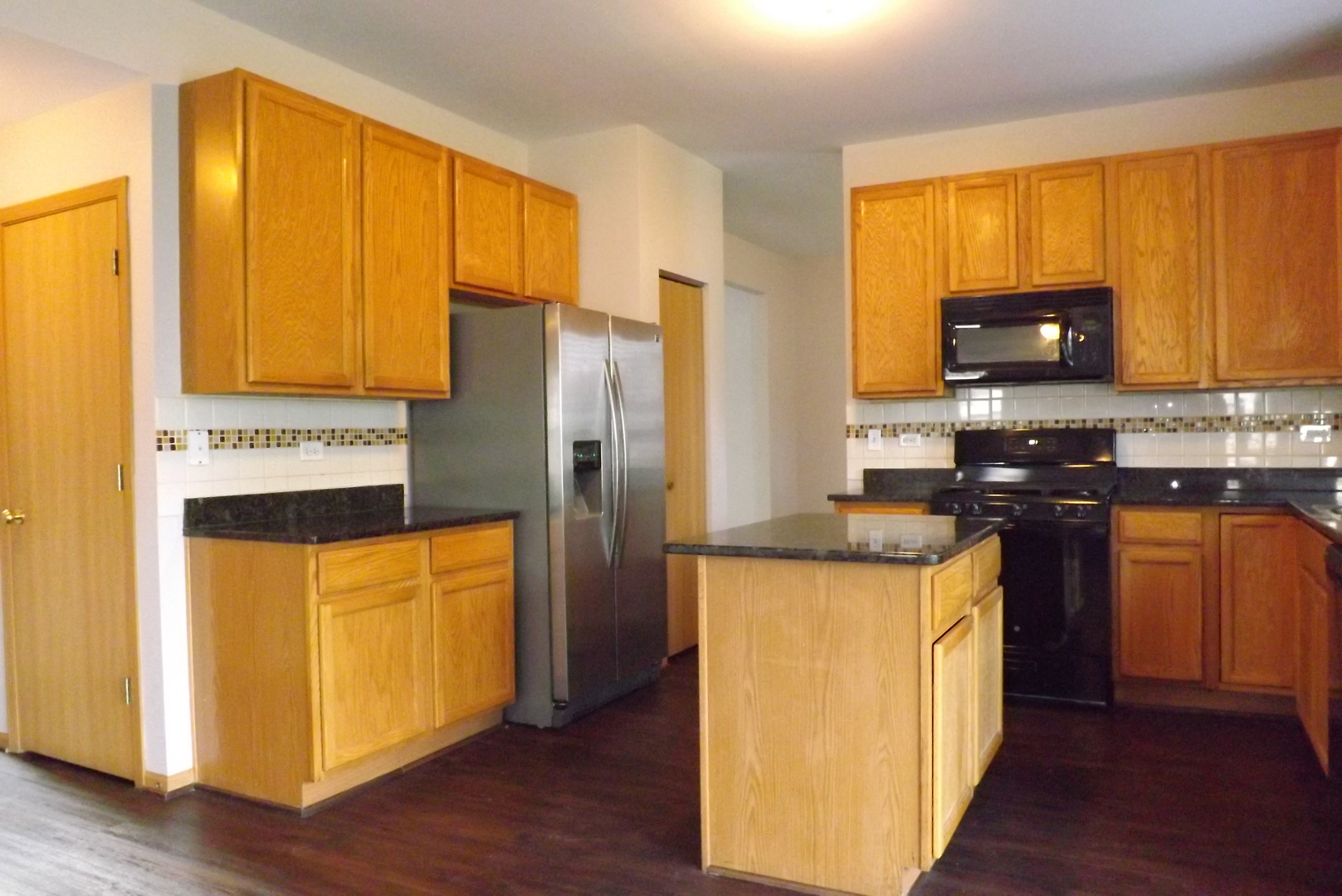 1865 Cattail Circle Aurora, IL 60504 - Photo 5 of 14 a kitchen with stainless steel appliances granite countertop a refrigerator a stove top oven a sink and dishwasher with wooden floor