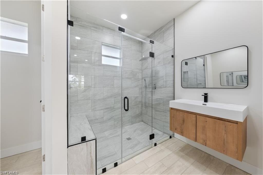 3008 23rd Street Southwest Lehigh Acres, FL 33976 - Photo 1 of 10 a bathroom with a shower sink and mirror