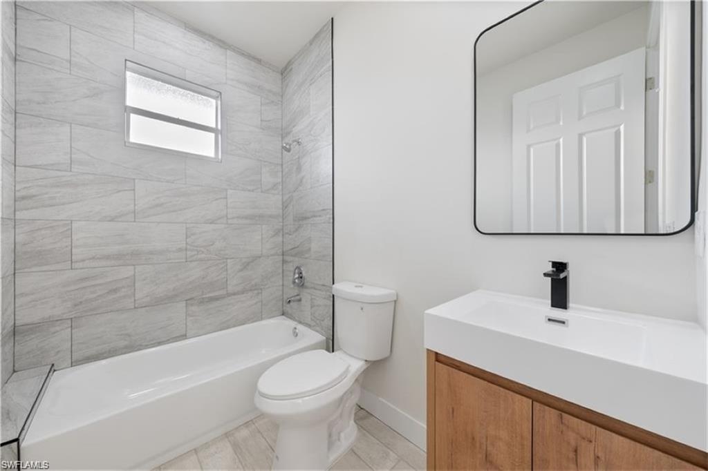 3008 23rd Street Southwest Lehigh Acres, FL 33976 - Photo 8 of 10 a bathroom with a sink a toilet and bathtub
