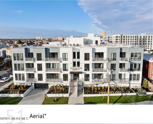 a front view of a building with streets and trees