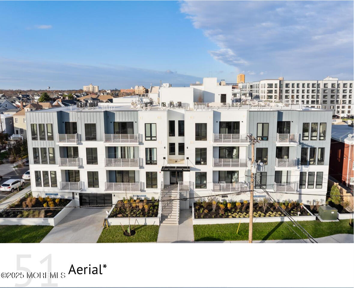 a front view of a building with streets and trees