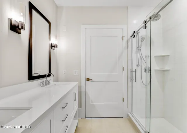 a bathroom with a shower sink and mirror