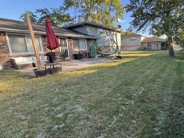 a view of a house with a yard patio and fire pit
