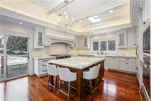 a kitchen with stainless steel appliances granite countertop a stove a refrigerator a sink dishwasher a dining table and chairs with wooden floor