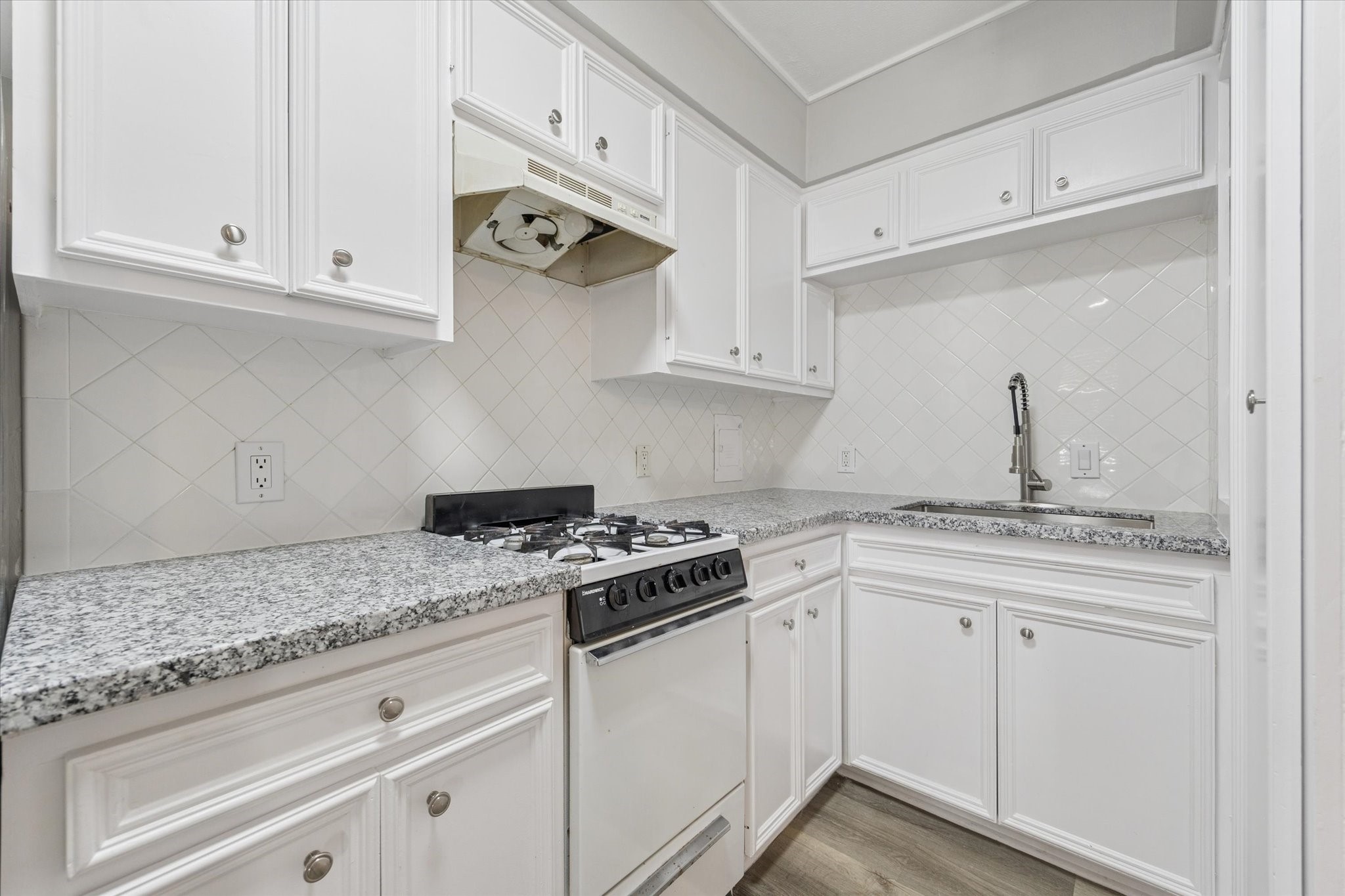 1901 Whitney Street, Unit 7 Houston, TX 77006 - Photo 4 of 10 a kitchen with granite countertop white cabinets and a stove