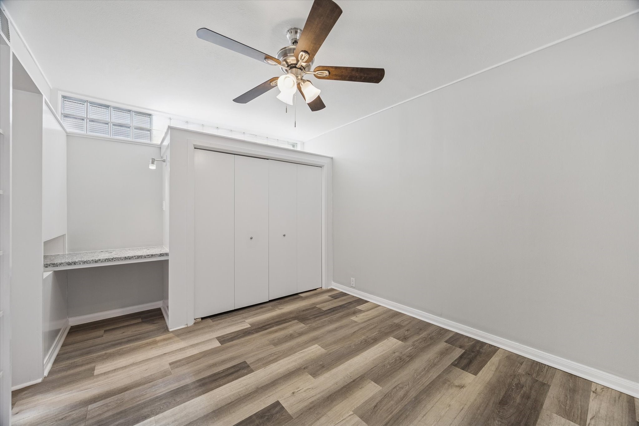 1901 Whitney Street, Unit 7 Houston, TX 77006 - Photo 5 of 10 an empty room with wooden floor and fan