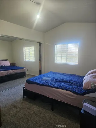 a bedroom with a bed a mirror and dresser