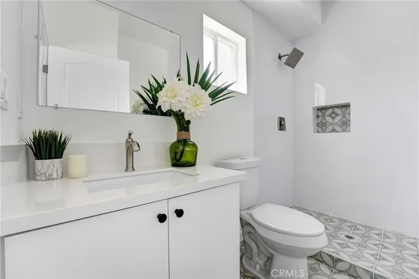 a bathroom with a sink a toilet and a mirror
