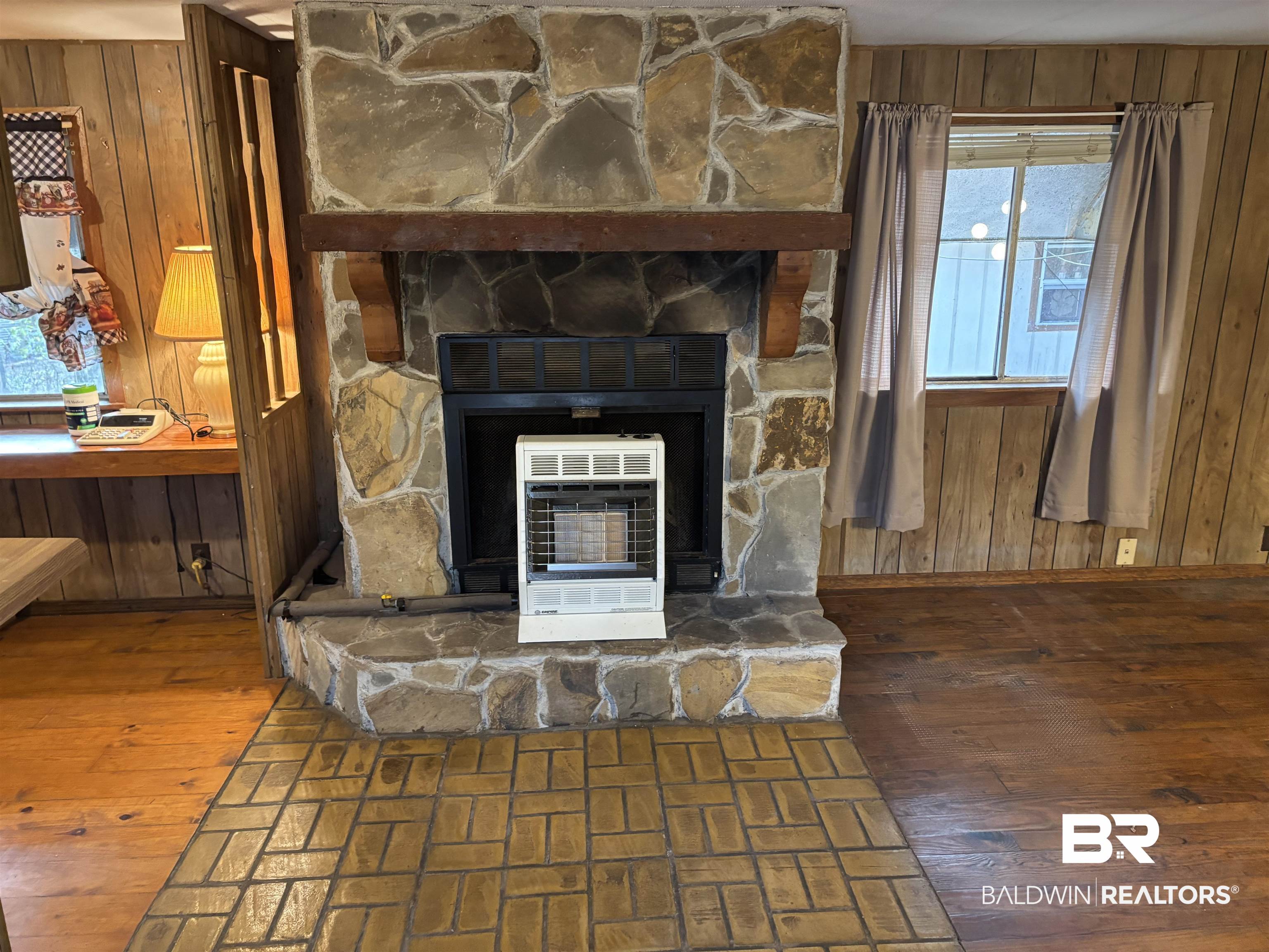 15575 Rogers Drive Chunchula, AL 36521 - Photo 29 of 42 Interior details with a fireplace, wood walls, heating unit, and wood finished floors