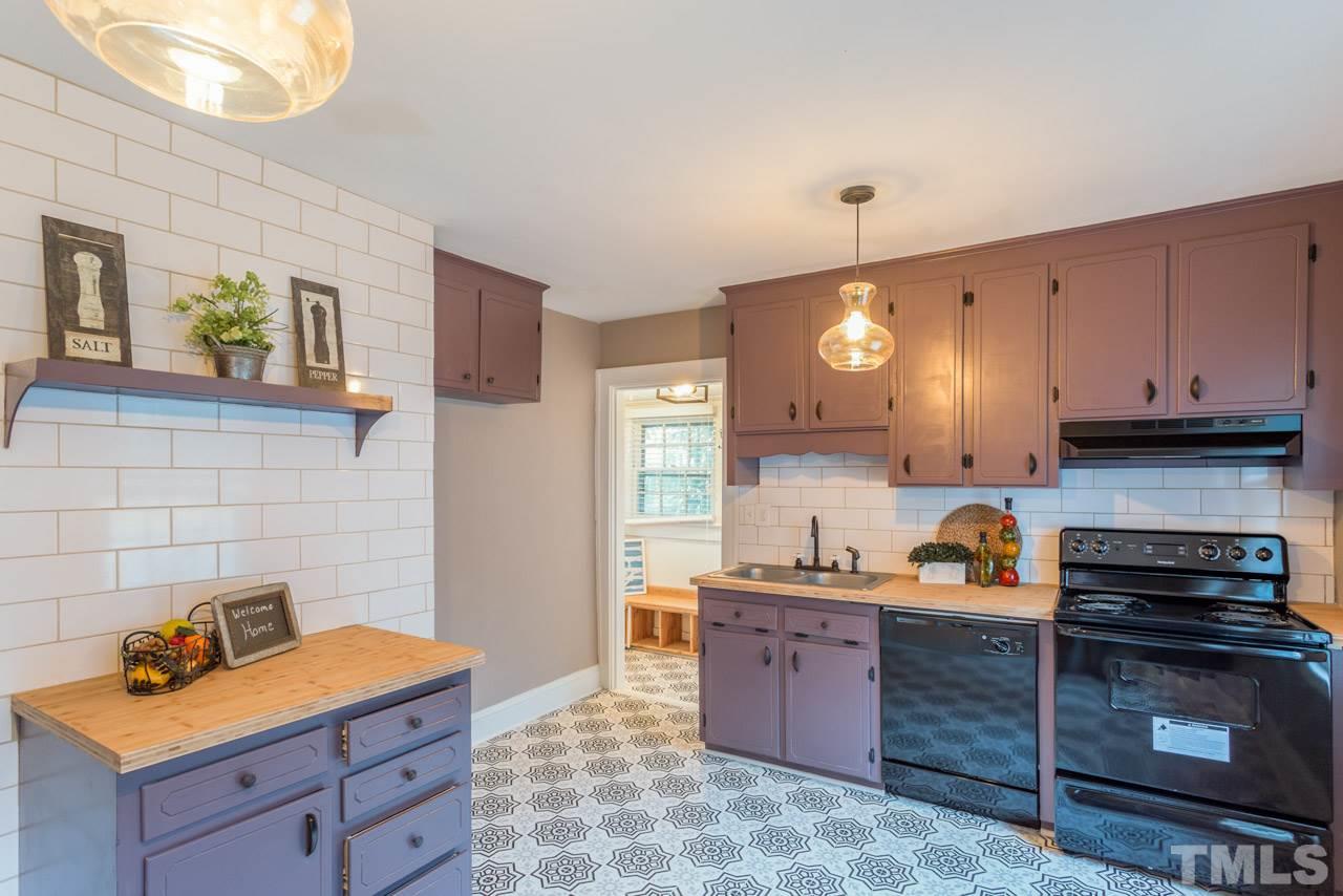 1215 Kent Road Raleigh, NC 27606 - Photo 5 of 11 a kitchen with granite countertop stove top oven and cabinets