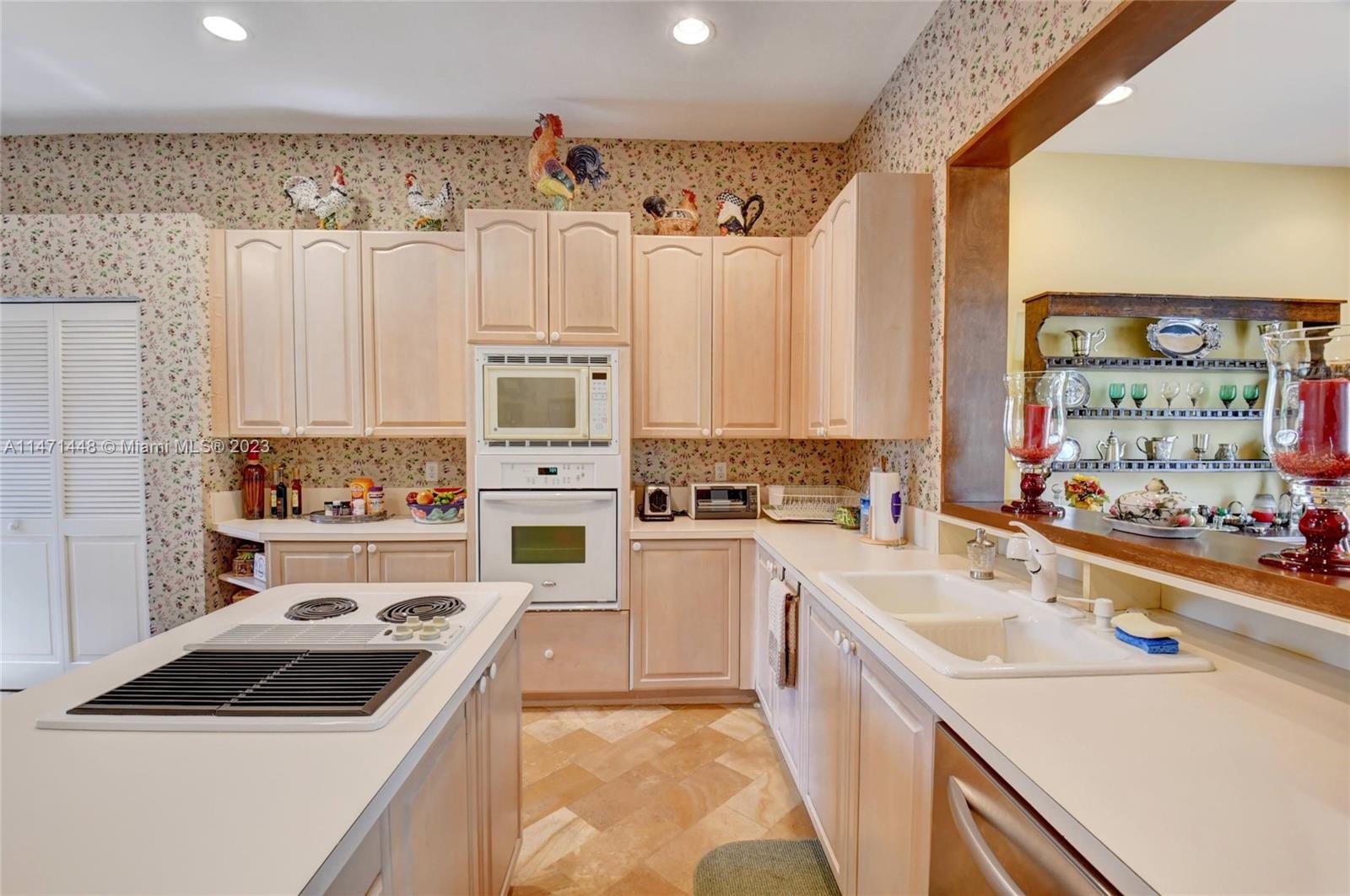 6325 Northwest 23rd Road Boca Raton, FL 33434 - Photo 33 of 84 a kitchen with a stove a sink and a refrigerator