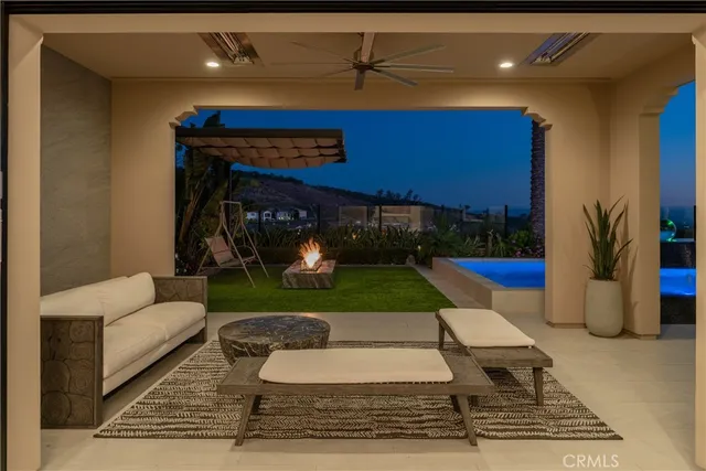 a living room with furniture a floor to ceiling window and kitchen view