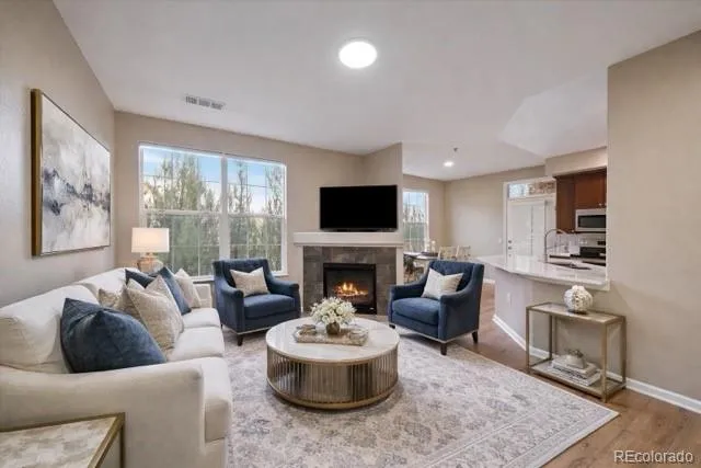 a living room with fireplace furniture and a large window