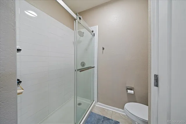 a bathroom with a granite countertop toilet and a shower