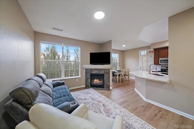 a living room with furniture a fireplace and a flat screen tv