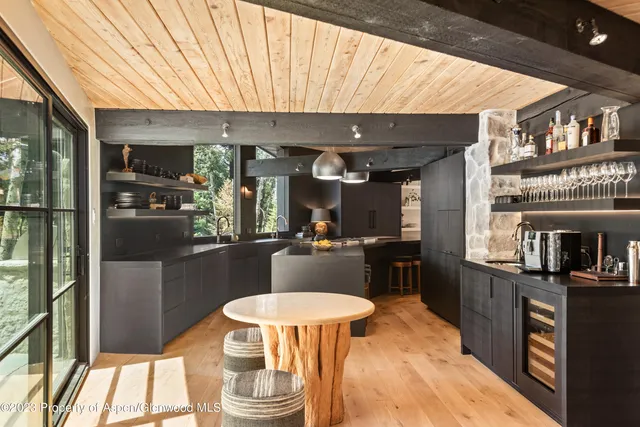 a kitchen with stainless steel appliances kitchen island granite countertop a table chairs and a refrigerator