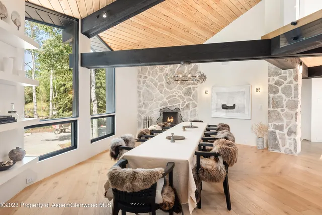 a dining room with furniture and a floor to ceiling window