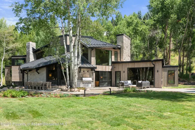 a view of a house with backyard and sitting area