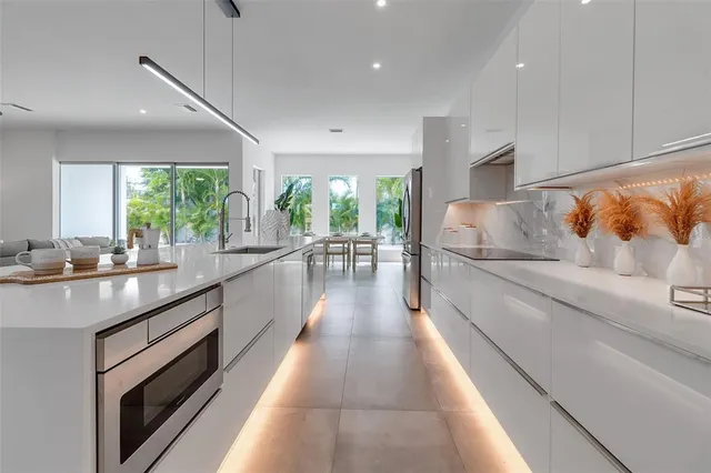 a large white kitchen with a large window