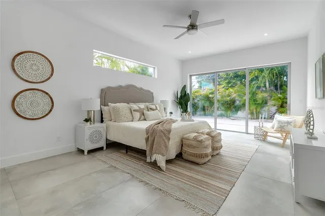 a spacious bedroom with a bed and ceiling fan