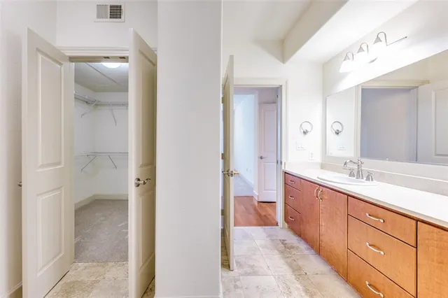 a spacious bathroom with a granite countertop sink mirror and a shower