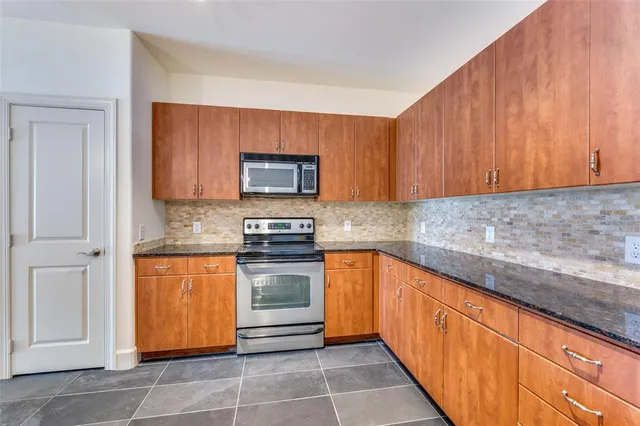 a kitchen with stainless steel appliances granite countertop a stove microwave and sink