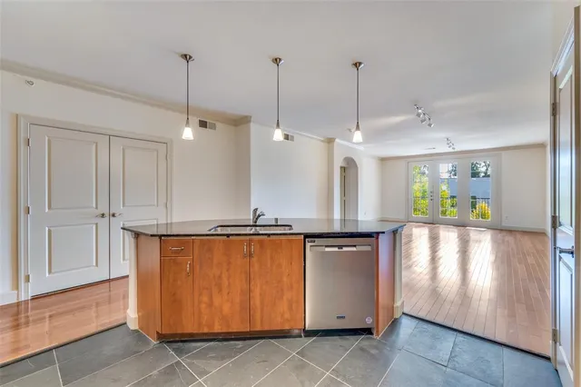 a view of a kitchen with kitchen island stainless steel appliances wooden floor and window